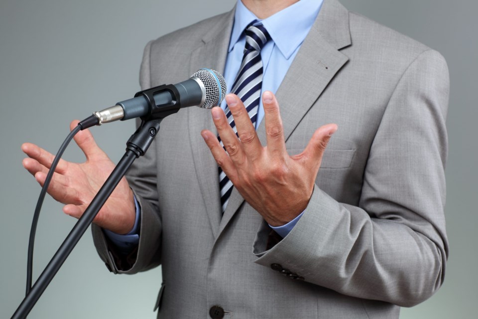 Businessman,Making,Speech,With,Microphone,And,Hand,Gesturing,Concept,For