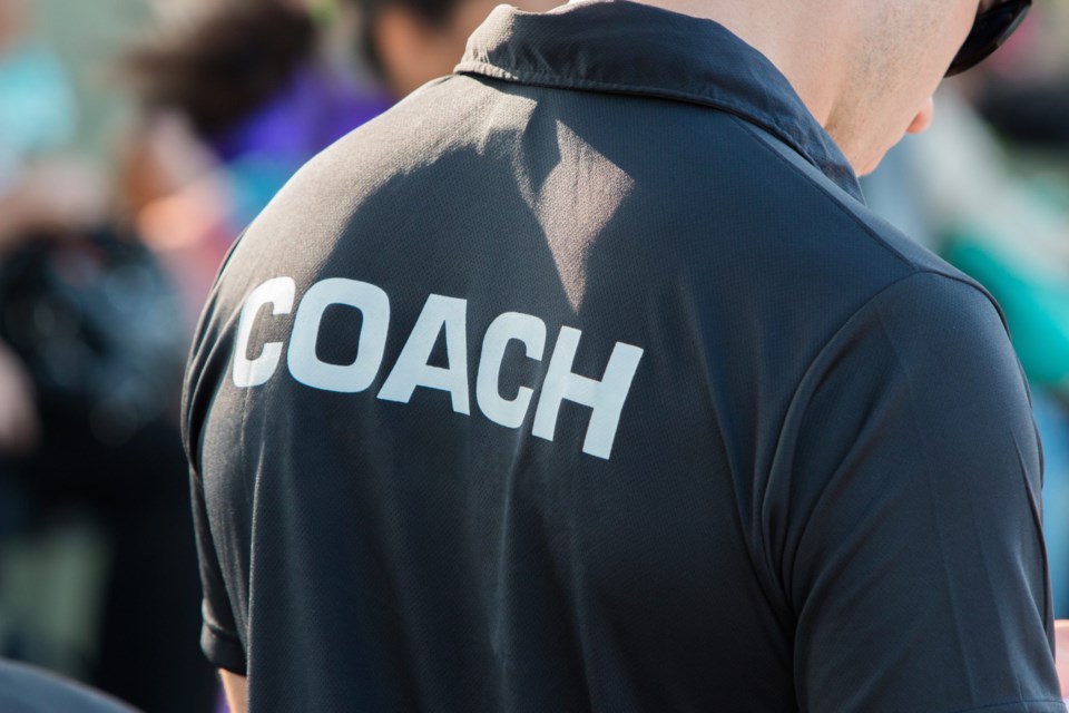Back,Of,A,Coach&#8217;s,Black,Shirt,With,The,White,Word