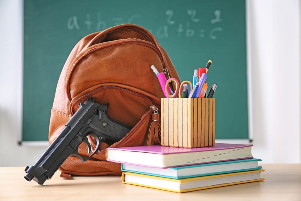 School,Stationery,And,Gun,On,Table,In,Class