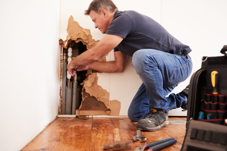 Middle,Aged,Man,Repairing,Burst,Water,Pipe