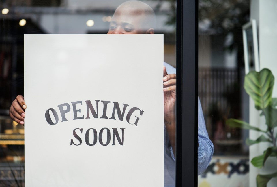 Man,Putting,On,Store,Opening,Soon,Sign