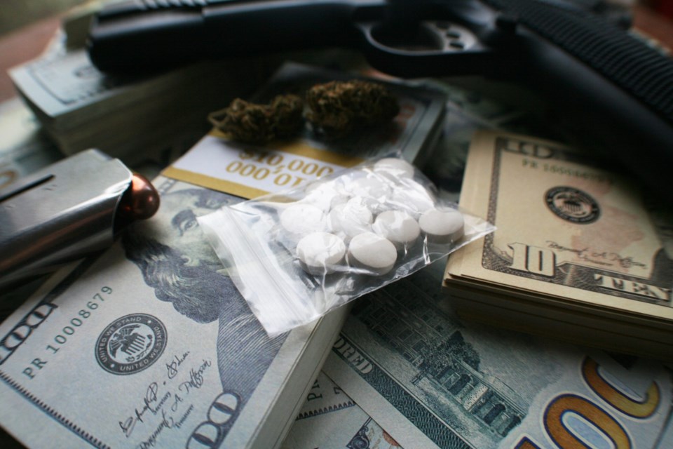 Drug,Dealer,Concept,With,Gun,,Pills,,Marijuana,&amp;,Cash