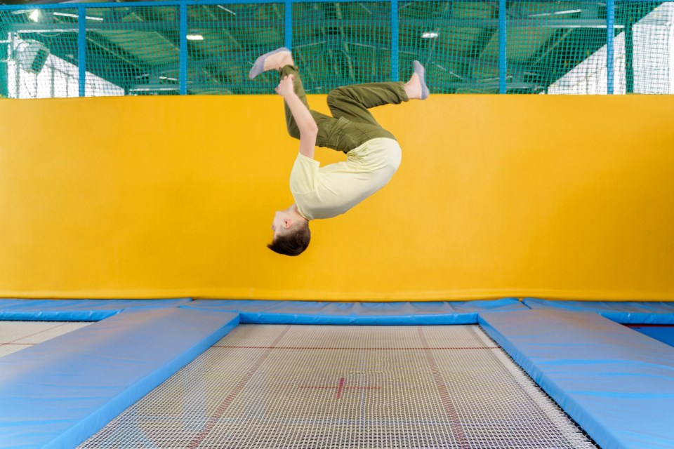 Teenage,Boy,Jumping,On,Trampoline,Park,In,Sport,Center