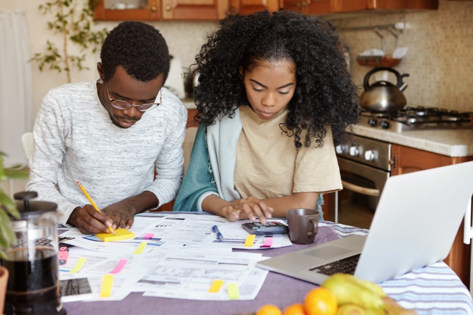 African,Man,And,Woman,Sitting,At,Kitchen,Table,With,Papers