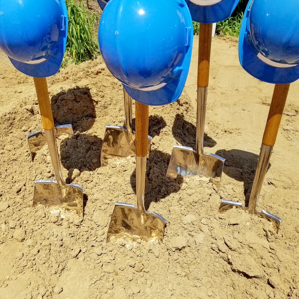 Industrial,Blue,Hard,Hats,On,Shovels,In,Dirt,For,Ground