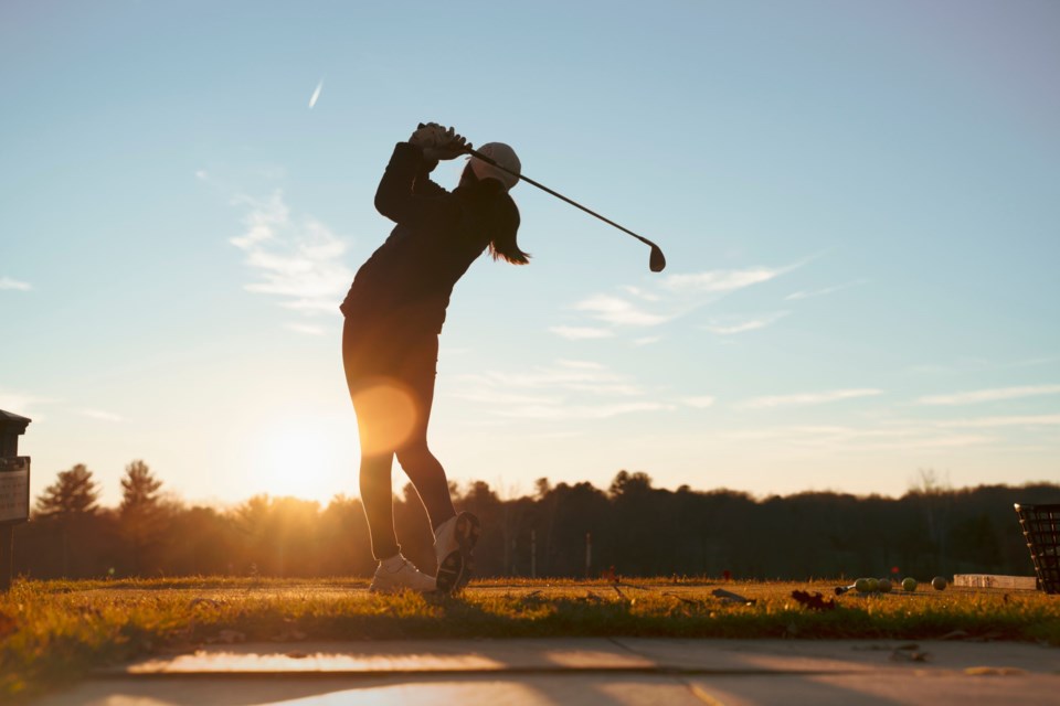 Young,Junior,Golfer,Practicing,In,A,Driving,Range,With,Beautiful