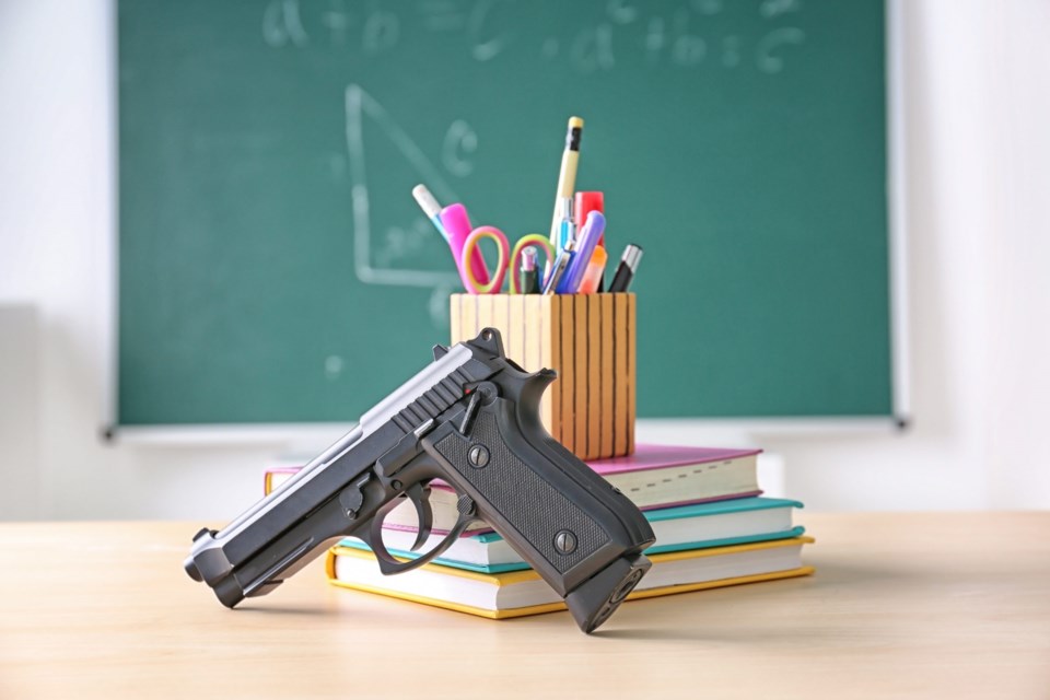 School,Stationery,And,Gun,On,Table,In,Class