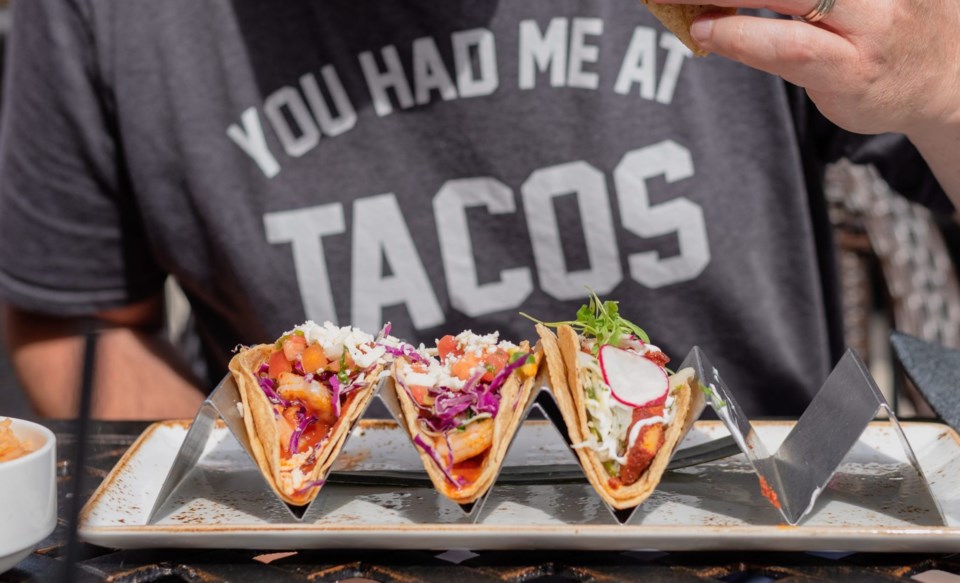 Closeup,Of,Man,Eating,Gourmet,Shrimp,Tacos,At,Outdoor,Restaurant