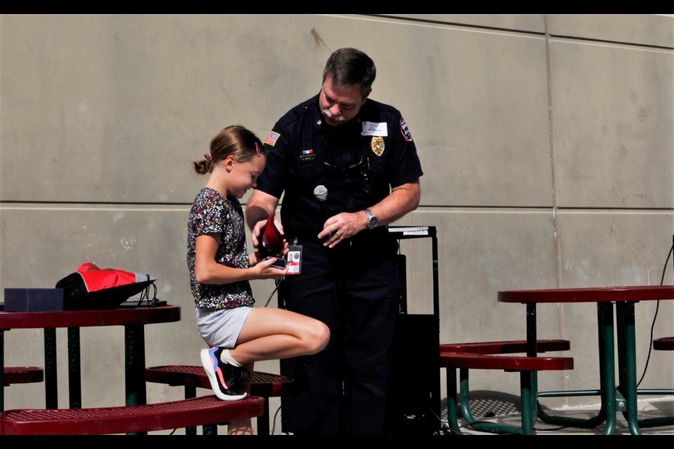 Addison Meyer, a sixth grader at Flagstaff Academy, receives an award recognizing her courage during a fire from Mountain View Fire Protection District Fire Marshal Jeff Webb.