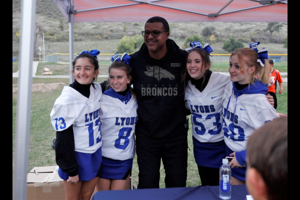 Former Denver Broncos player Steve Atwater poses with cheerleaders on Friday at Lyons Middle Senior.