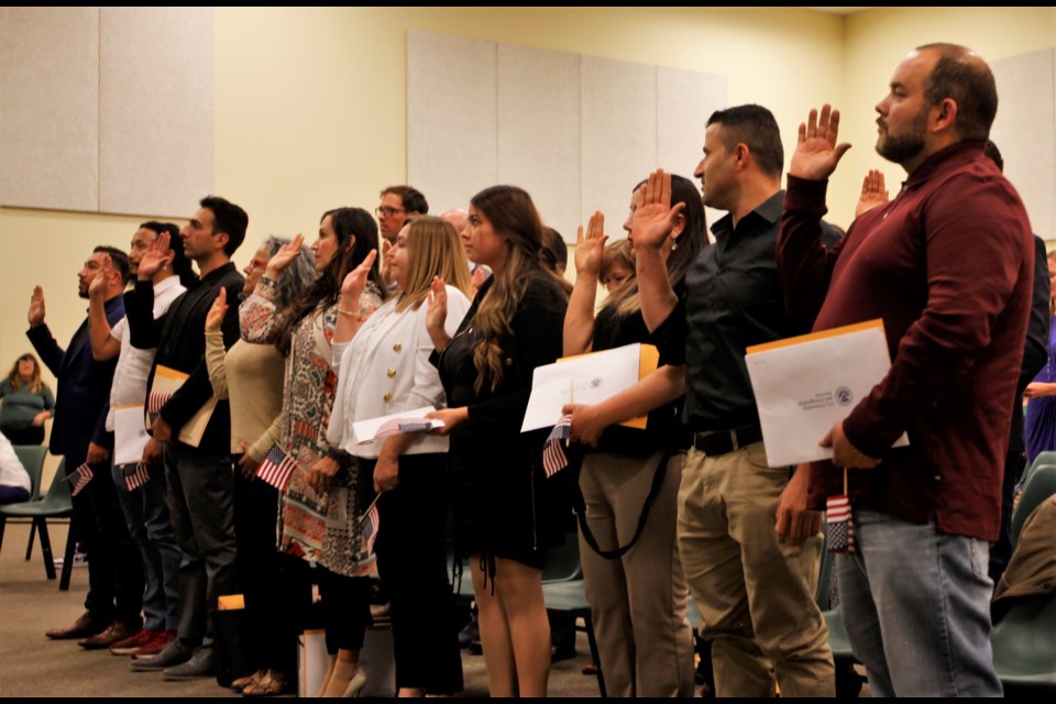 Twenty-one immigrants take the Oath of Allegiance to become U.S. citizens on Tuesday at Twin Peaks Classical Academy in Longmont.