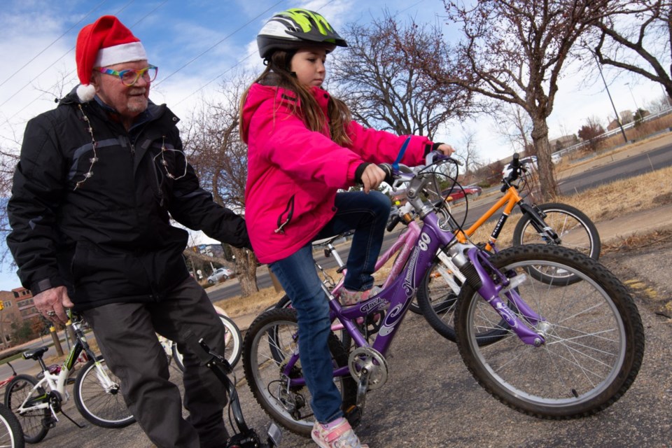 Community Cycles volunteer Dean Fogerty helps Claire Rothschild, 8, test ride a bicycle in Boulder, Colo., on Dec. 11, 2021.

Colorado Public Radio