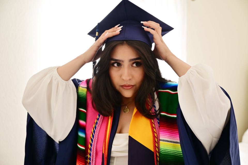 GREELEY, CO - MAY 7: Maria Bocanegra Tejeda, 22, puts on her graduation gown and cap for the 2022 University of Northern Colorado graduation ceremony at her home in Greeley, Colorado on Saturday, May 7, 2022. (Photo by Hyoung Chang/The Denver Post)

COLab