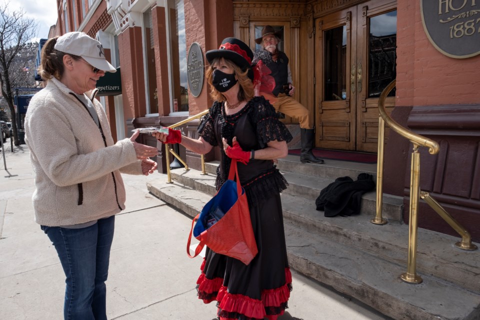 Dressed in Old West attire, Cathy Roberts (left) and Scott Perez (right) mix it up with locals and visitors while on a mission in Durango, Colorado: to encourage mask use during the pandemic. They give out free masks and sometimes stand for a quick photo opportunity with tourists. (Jeremy Wade Shockley for KHN)