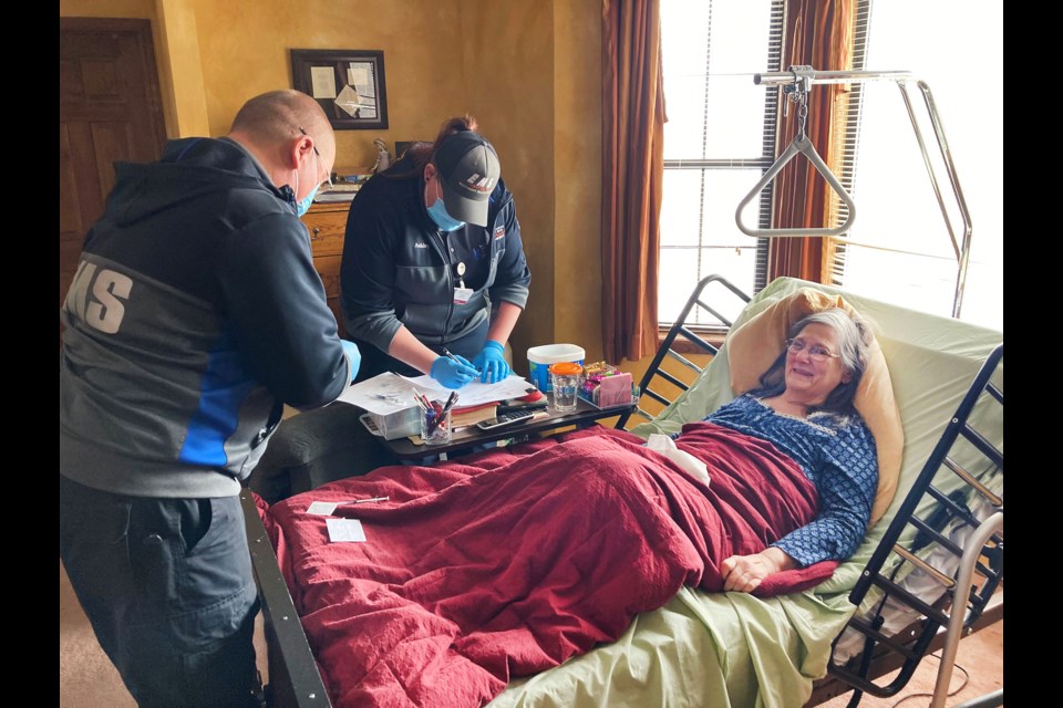 Paramedics with Southwest Health System prepare to administer Tresa Gleeson's second dose of the Pfizer coronavirus vaccine at her home near Cortez, Colorado. The team traveled around the region to vaccinate people unable to leave their homes. (Anthony Nicotera/The Journal)