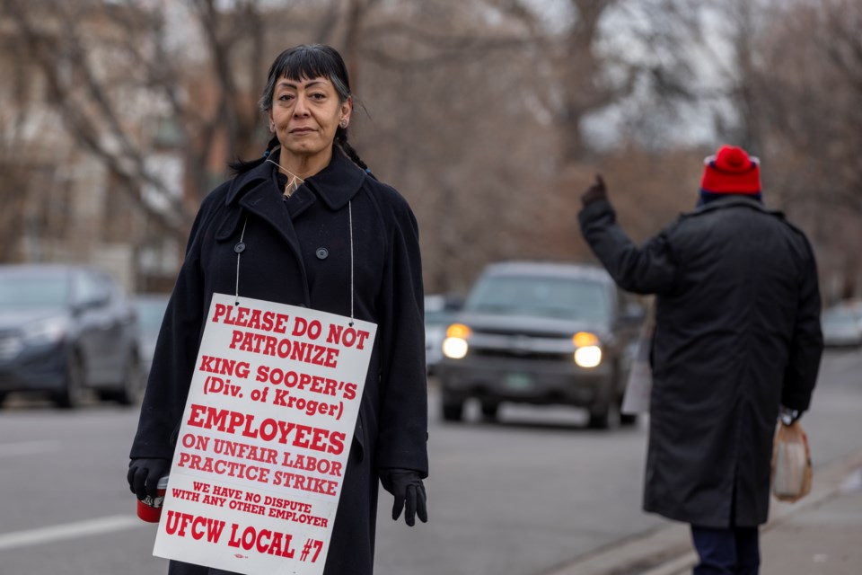 Gigi Jones said she is striking because she currently has to work overtime at her King Soopers job and work part time at two other jobs to pay her bills. She is hoping a new contract could help her work less. Gigi removed her mask for the portrait then put it back on to return to picketing. (Giles Clasen for Denver VOICE)

The Denver VOICE