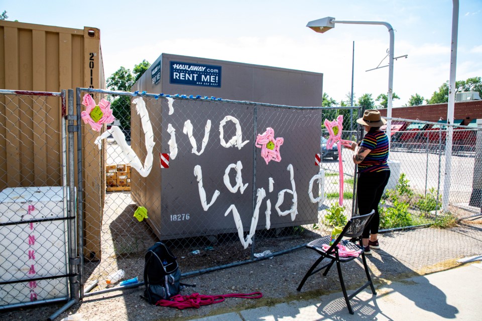 Local artists, sponsored by the LDDA, weave colorful fabrics through the fence around the construction site at 6th Ave and Main St.