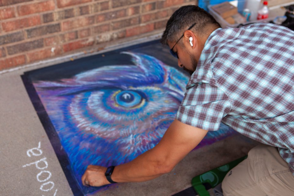 Jon Fukuda works on his submission for the Longmont CHALKMONT competition on Aug. 27. The winner will be anounced during the Sept. 10 ArtWalk. Photo by Ali Mai
