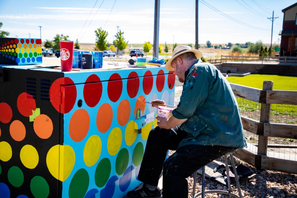 Evan Colbert working on his Rainbow Machine outside the Innovation Center