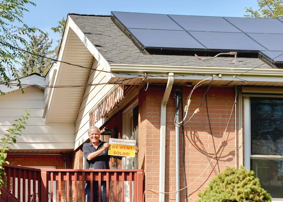 Broomfield resident Burton St. John poses in front of his recently installed rooftop solar system. Burton is a member of Broomfield's Solar Co-op, established by Solar United Neighbors in 2022. 