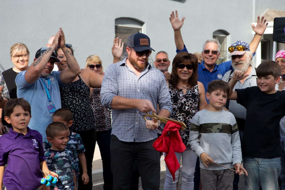 Owner and founder of Columbine Roofing LLC Jeremy Riehl(center) cuts the ribbon at the official ribbon cutting ceremony for the company's Longmont location on Sept. 16. Photo by Ali Mai