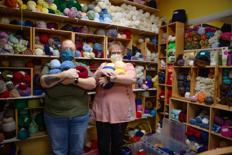 Owners of The Hidden Treasure 2 Aimee Esch(left) and Sandra Noonan(right) hold bundles of yarn on Sept. 10. After a year and a half of sewing and donating masks, they are refocusing on their craft and consignment store. Photo by Ali Mai

