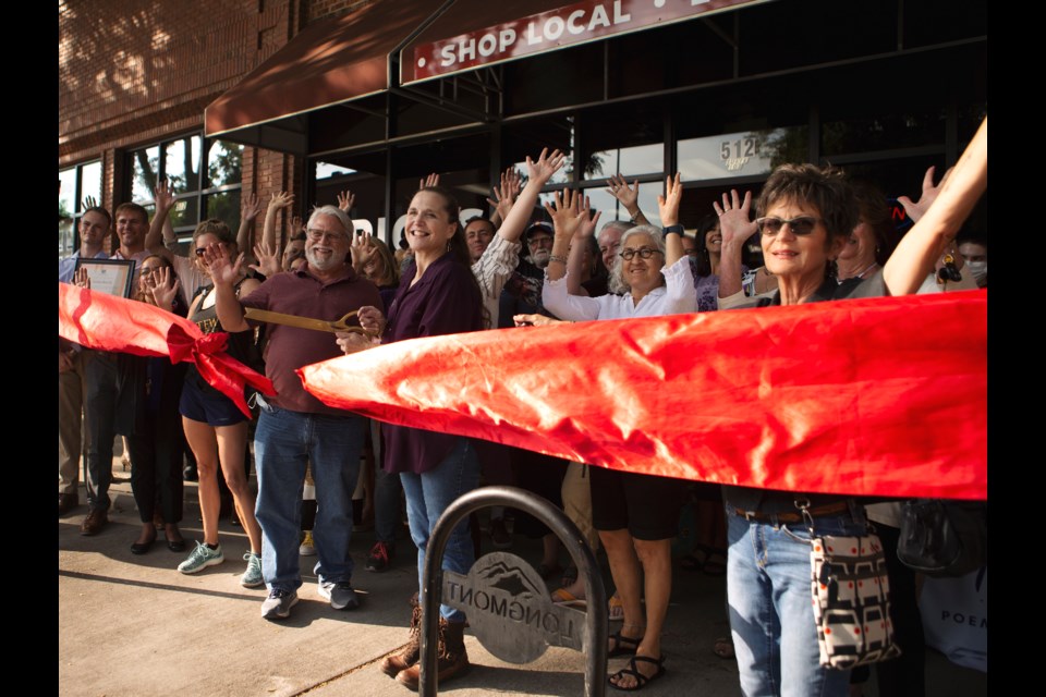 Owner of Bricks Retail Jennifer Ferguson(center) cuts the ribbon at the ribbon cutting ceremony of the Longmont store on Sept. 28. The ceremony was postponed to the one year anniversary of the shop due to pandemic precautions. Photo by Ali Mai