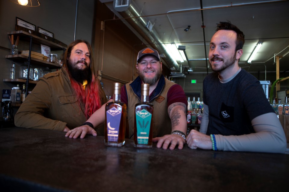 From Left to right: Copper Sky Distillery staff Isaac Haefner, Master Blender, Mike Root, owner and founder, and Collin Richardson, operations, behind the bar of the current location on Colorado Avenue on March 9. The distillery is moving locations to the developing South Main Street area in Longmont in April 2022. Photo by Ali Mai | Longmont Leader