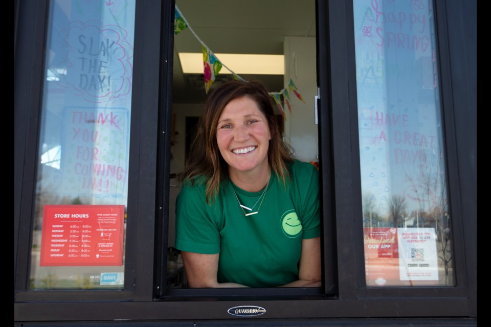 Megan Snyder, franchise owner of the Scooterâs Coffee in Longmont, on Apr.18 poses for a photo out of the drive-thru window. Photos by Ali Mai 