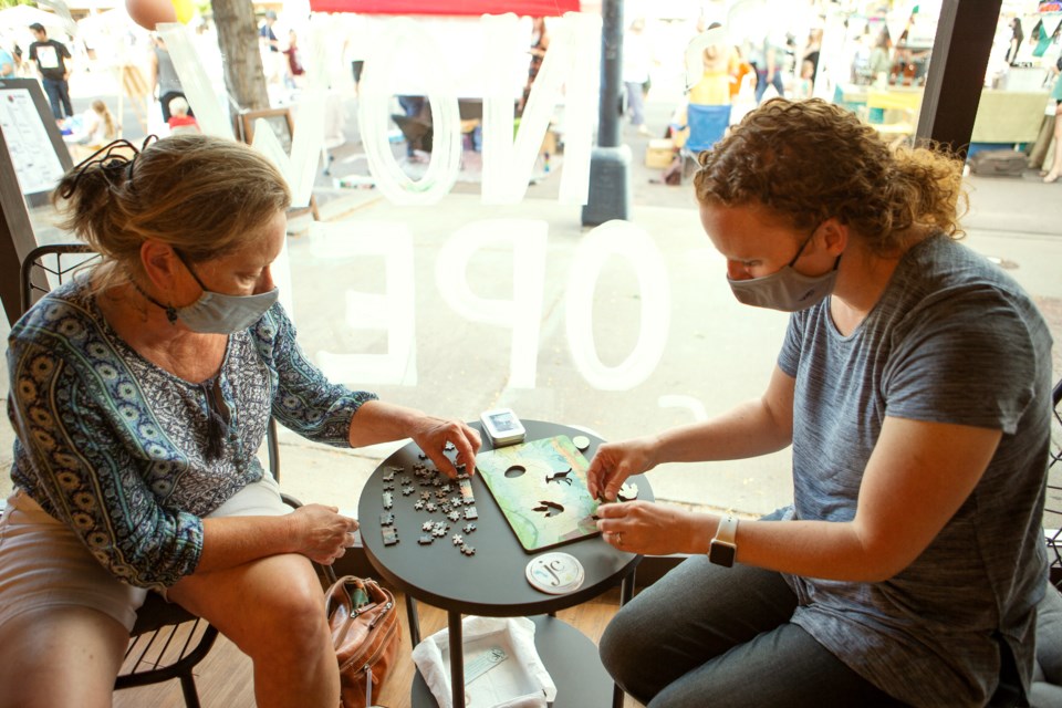 The MECO Coffee Collective vendors â Elm Springs Essentials owner Kate McKenna(left) and Joyful Chaos Creations co-owner Sarah Parker(right) â work on Joyful Chaos Creations puzzles at the grand opening of the store on Sept. 11. Photo by Ali Mai