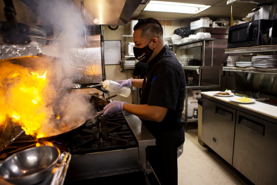 Raymundo Zitlalpopoca, chef at Rosario's Peruvian Restaurant, cooks for the restaurant's first order on Sept. 16. Photo by Ali Mai