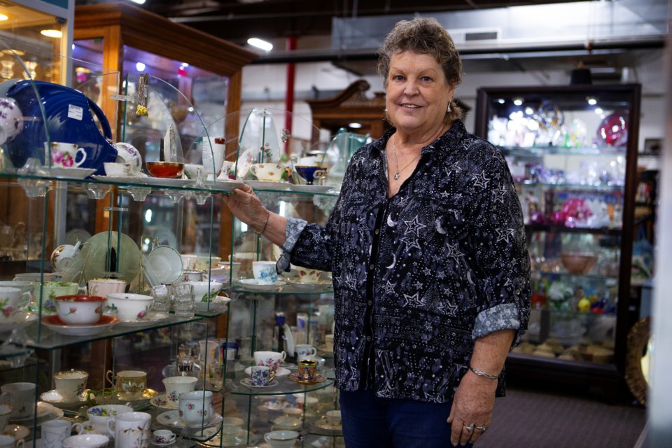 Marlena Toohey, owner and co-founder of Tables To Teacups Indoor Flea Market in Longmont, stands with one of her favorite consignment sections featuring teacups on Oct. 20. Photo by Ali Mai