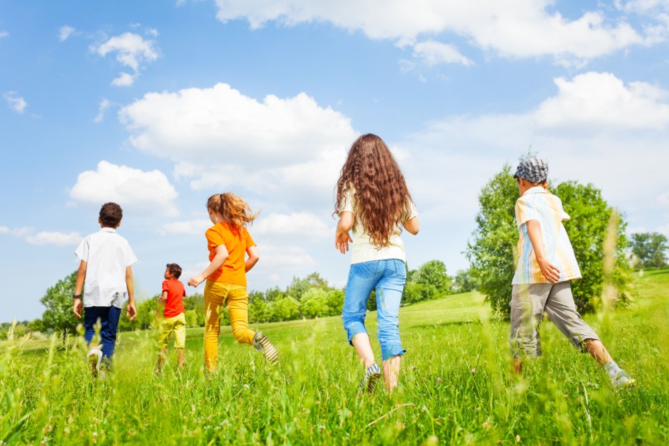 Children back running in other direction outside in summer