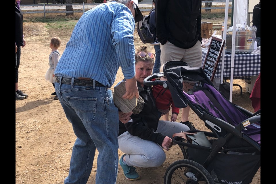 Local farmer helps patron load her stroller. 