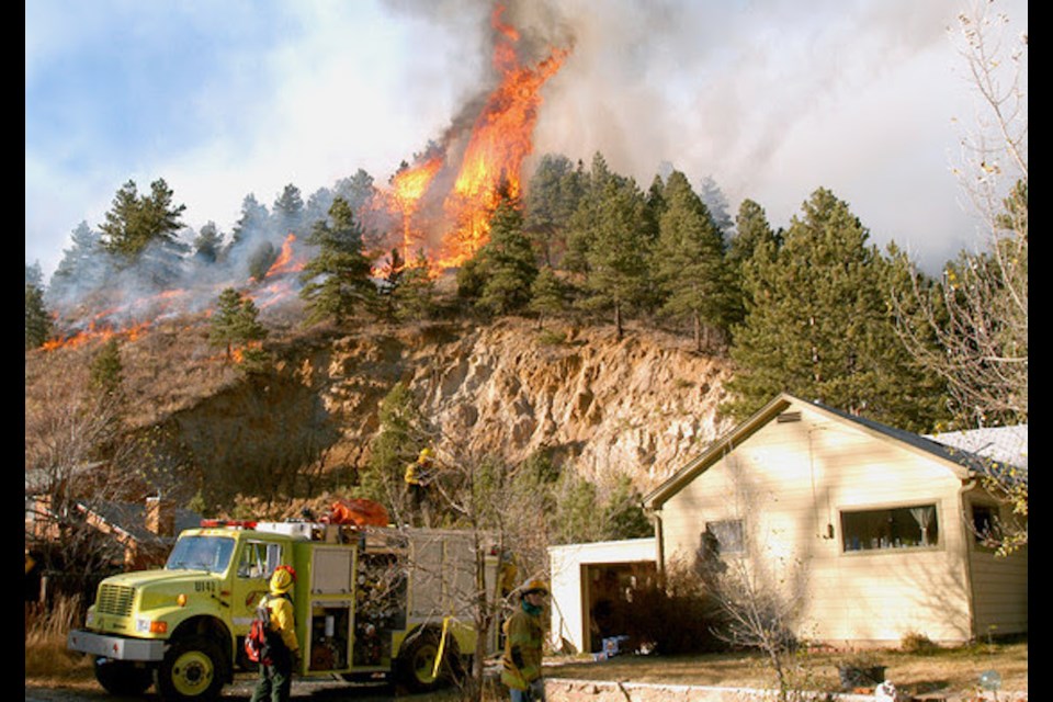 The Overland Fire advances into the town of Jamestown, Colorado, on Wednesday, October 29, 2003. Fire engines were stationed at the homes and buildings to protect the structures from the flames.