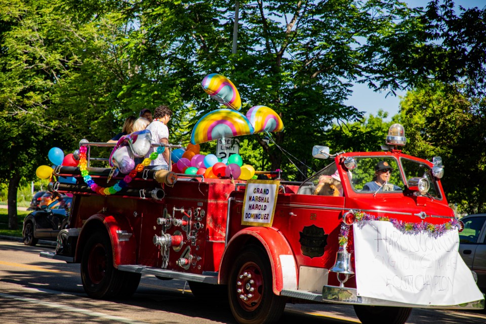 City Manager, equity champion and Pride Grand Marshal Harold Dominguez and his family riding in an old firetruck at the head of the Pride motorcade.