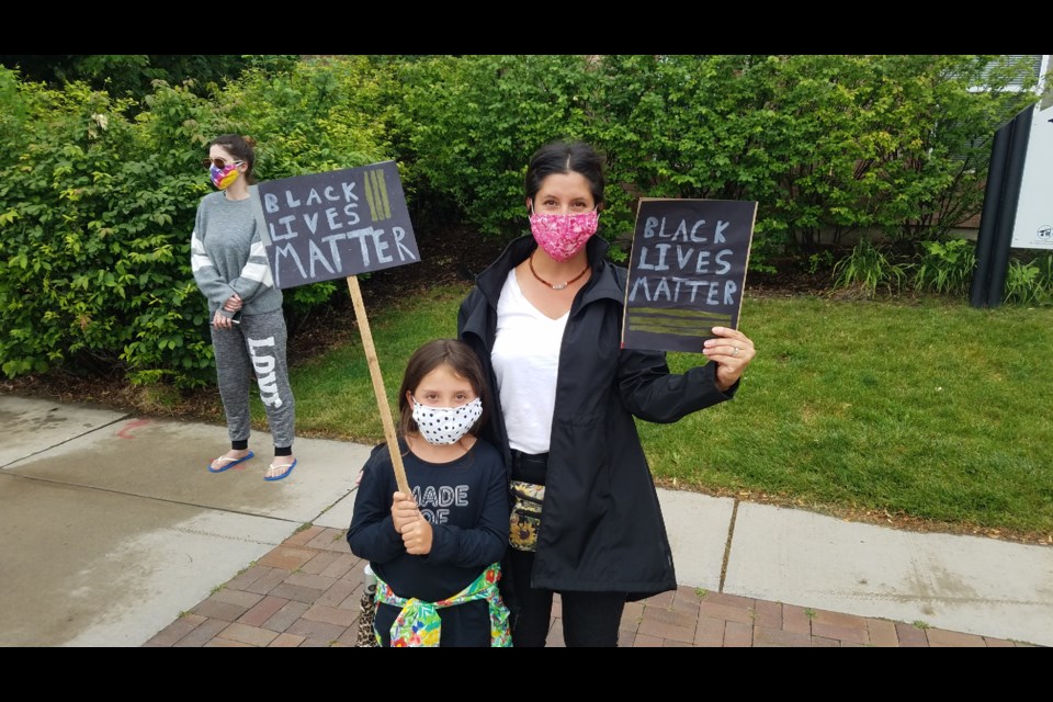 Neian Corr and her daughter, Lilah, 8 carry signs designed by Lilah at the Juneteenth demonstration on Friday. 
(Photo by Monte Whaley)
