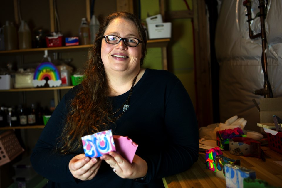 Shannon Hames, soapmaker and owner of The Science of Bliss, holds up two of her favorite soaps "Black Raspberry Vanilla" and "Wild Rose" on March 17, 2021, at her Longmont home.  She creates and stores her soaps in her basement. 