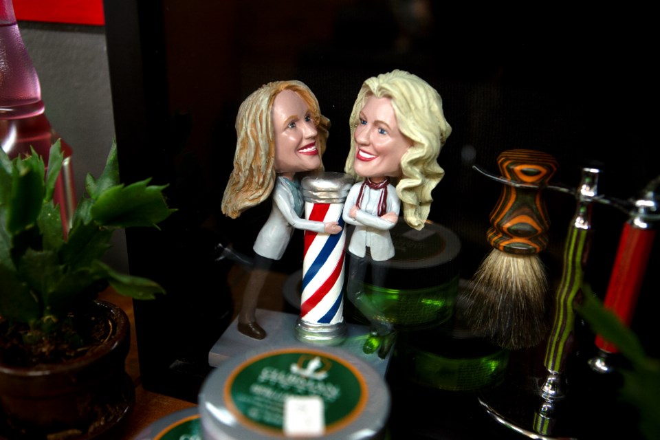 A small figurine of Deluxe Barbers & Styling Shop owners Susan and Teresa Shaheenâs is displayed at the Longmont barber shop. The statue was gifted to them from a family member. Photo by Ali Mai | ali.mai.journo@gmail.com