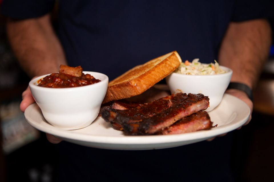 Georgia Boys BBQ owner Matt Alexander holds a plate of rib, sliced brisket, BBQ beans, coleslaw and Texas toast at the Longmont location âThe Shackâ on July 14. Photo by Ali Mai | ali.mai.journo@gmail.com