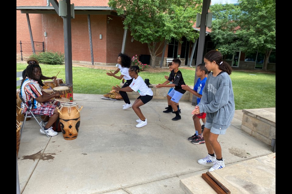 Kids learn African dancing while listening to Selasee Atiase and his student play the African drums. 