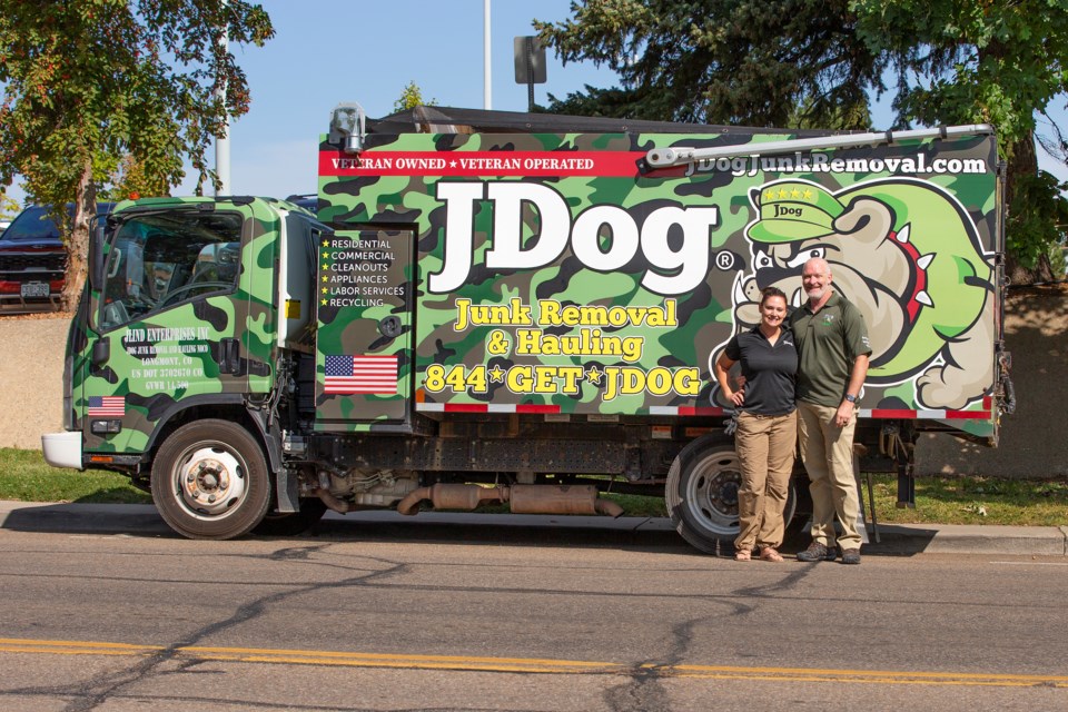Longmont couple Laura and John Lindsay with their JDog hauling truck on Sept. 28. Laura, VP, and John, owner, started operations on their franchise business JDog Junk Removal and Hauling Boulder County and Loveland in August. Photo by Ali