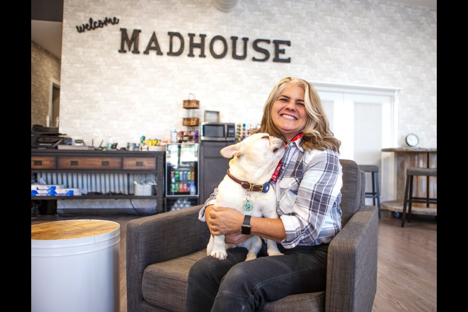 Victoria Bellah, owner of Madhouse Station in Longmont, sits in the new coworking space with her dog Louie GrumpyPants on Sept. 29. The coworking and event venue builds off of the Madhoyse 4 Paws brand, a pet boutique. Photo by Ali Mai