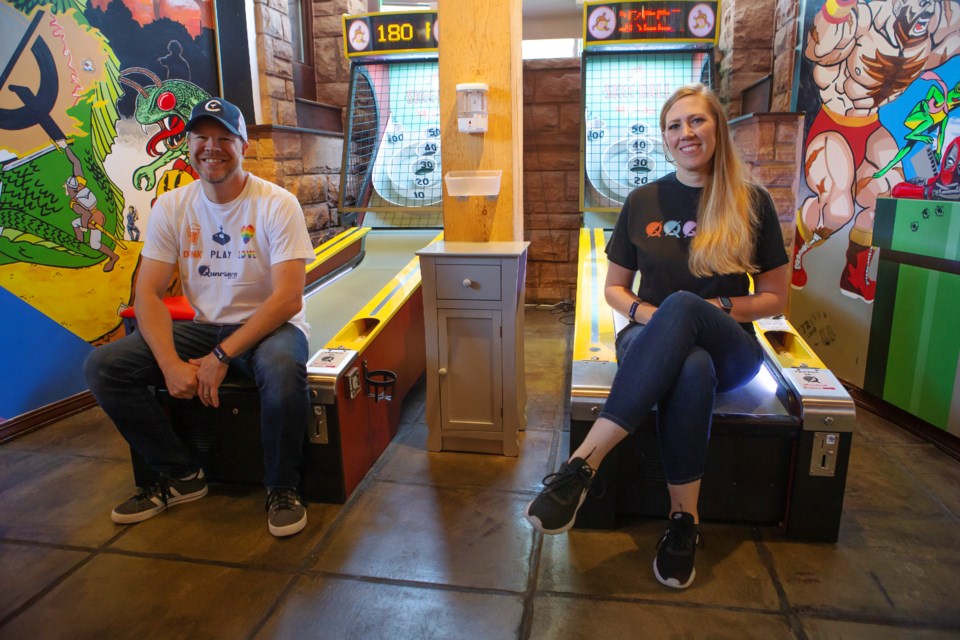 Quarters Bar and Arcade owners Luke and Emily Kunselman sit on the arcadeâs skee-ball machines on June 15. The bar arcade will restart its skee-ball tournament on July 19 and 20. Photo by Ali Mai | ali.mai.journo@gmail.com