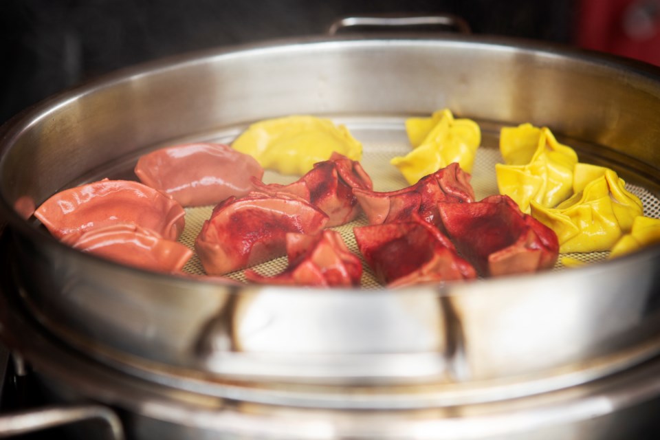 Shinkyu-No food cart dumplings steam for an order at a pop-up at Spirit Hound Distillers on May 28. Flavors pictured: Citrus Pork(orange), Fennel Pork(red), and Salmon and Mustard Greens(yellow). Photo by Ali Mai | ali.mai.journo@gmail.com