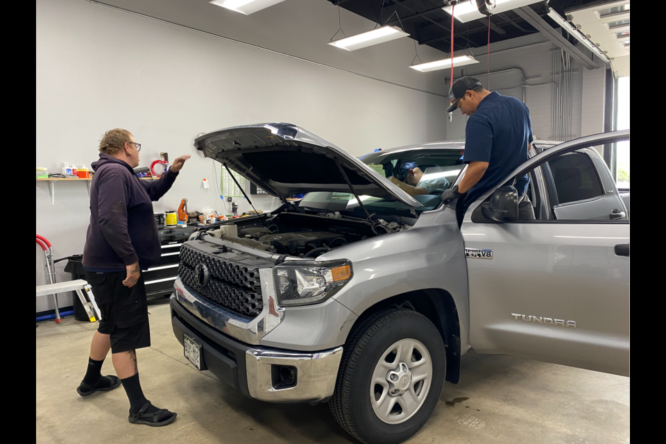 Employees of Novus Glass in Longmont work on the windshield of a customer's car. 