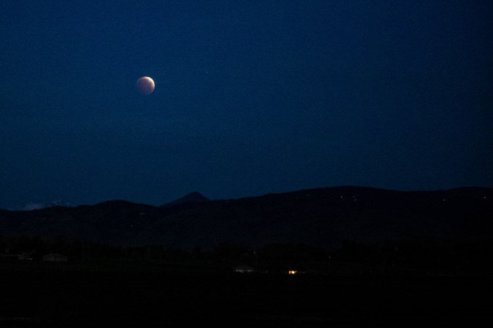A total lunar eclipse on May 26, 2021, became obscured by hazy clouds and early morning light as it reached totality over the Front Range.