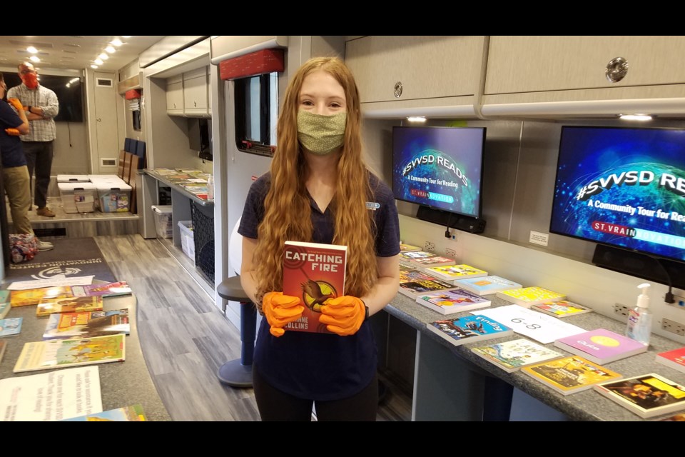 Longmont High senior Shelby Seyvold, 17, holds one of the books available from the St. Vrain Valley School District's mobile Innovation Lab on June 30, 2020.
(Photo by Monte Whaley)
