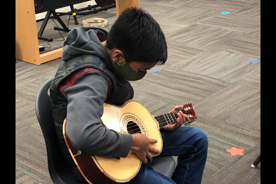Mateo begins his morning by warming up his guitar.
