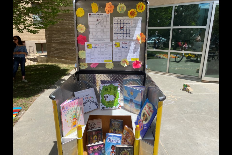 A stand at the Summer Reading Kickoff party showcasing some of the books at the library, the Bingo sheet, and a list of events for the summer at the library. 